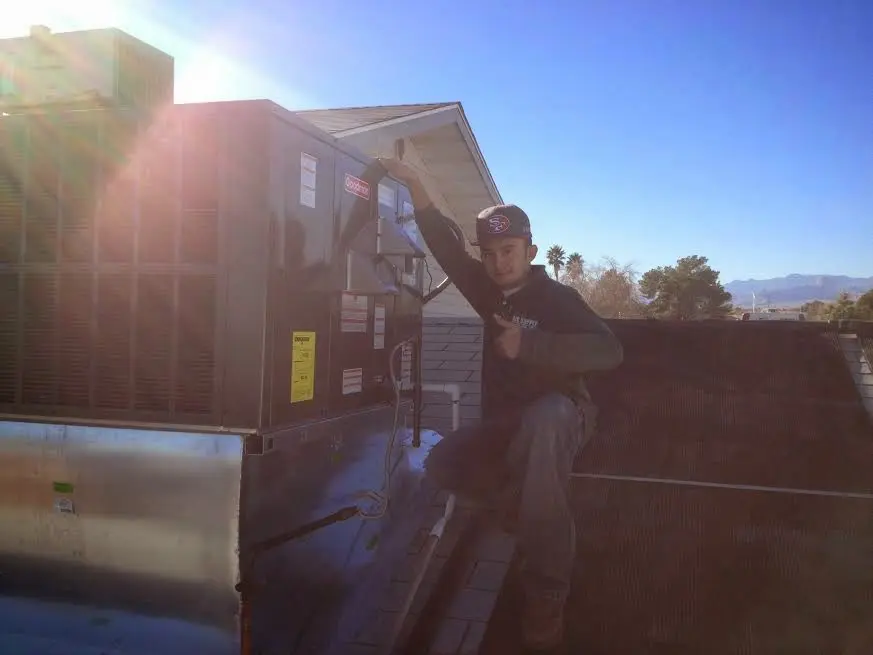 HVAC technician performing AC Tune-Up on a rooftop unit in Los Angeles